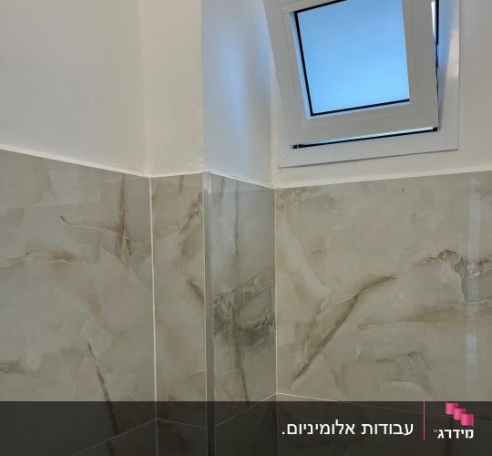 חלון אלומיניום קטן פתוח בקיר חדר אמבטיה